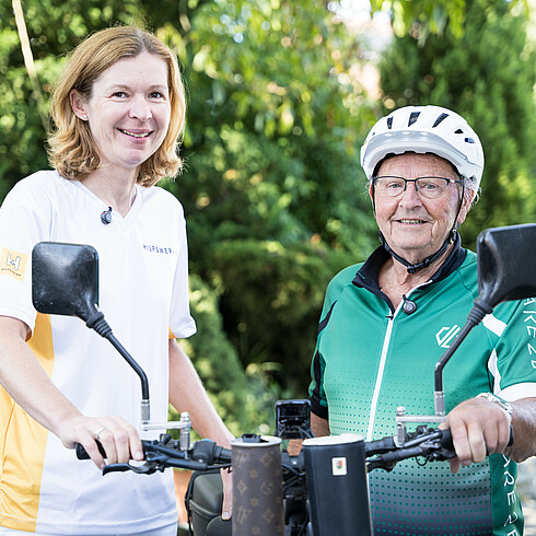 Älterer Herr und Pflegekraft mit Fahrrad