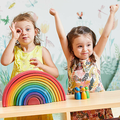 Drei Kinder im Vorschulalter formen mit den Händen ein Fernrohr und gucken durch