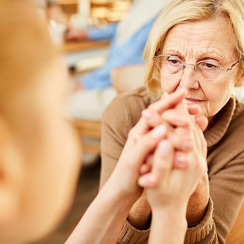 Frau, etwas bedrückt, interagiert mit einem Mädchen.