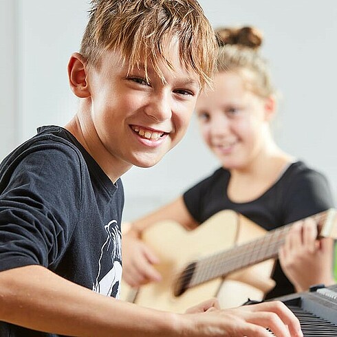 Bursche beim E-Piano Spielen in der Ganztagesschule