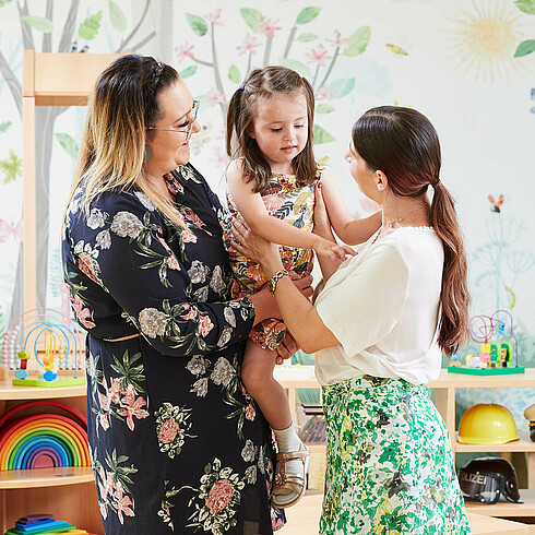 Mutter übergibt ihre kleine Tochter der Tagesmutter 