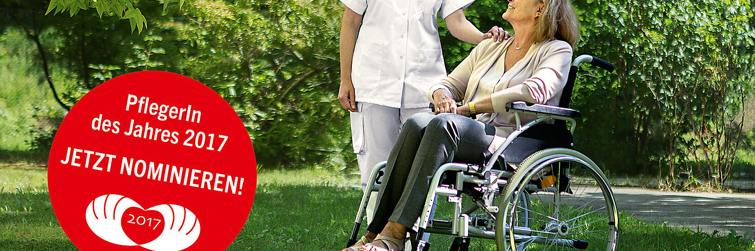 Eine Pflegerin blickt auf eine ältere Dame im Rollstuhl. Beide sind in einem grünen Park. 