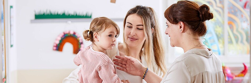 Mutter übergibt ihre Tochter in die Obhut der Kindergartenpädagogin