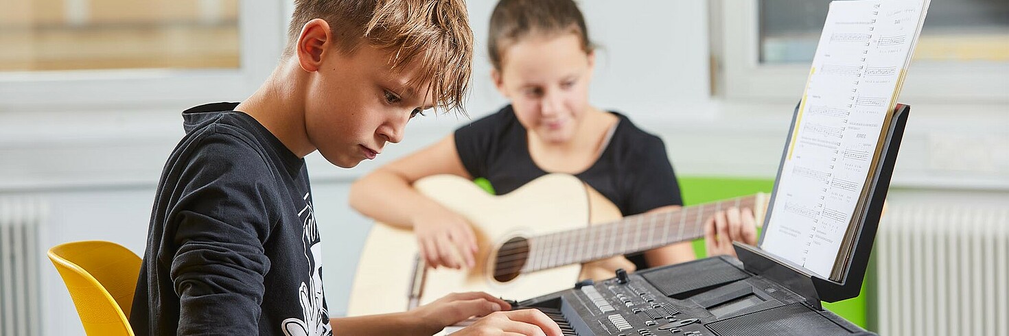 An Bursche beim E-Piano Spielen bei der Schülernachmittagesbetreuung