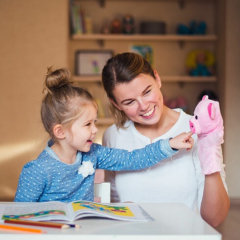 Mutter spielt mit Tochter und Handpuppe