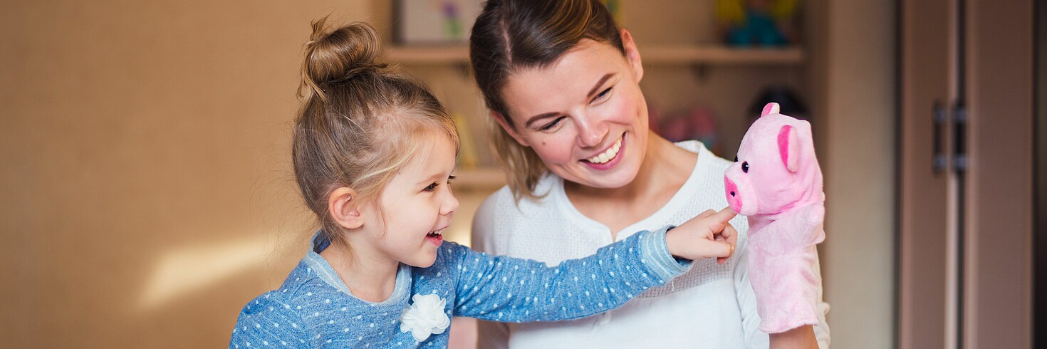 Mutter spielt mit Tochter und Handpuppe