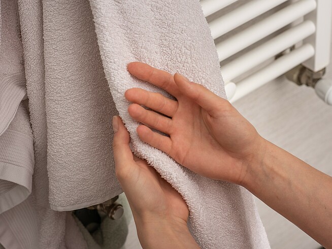 Nahaufnahme von Händen, die an einem weichen Handtuch getrocknet werden