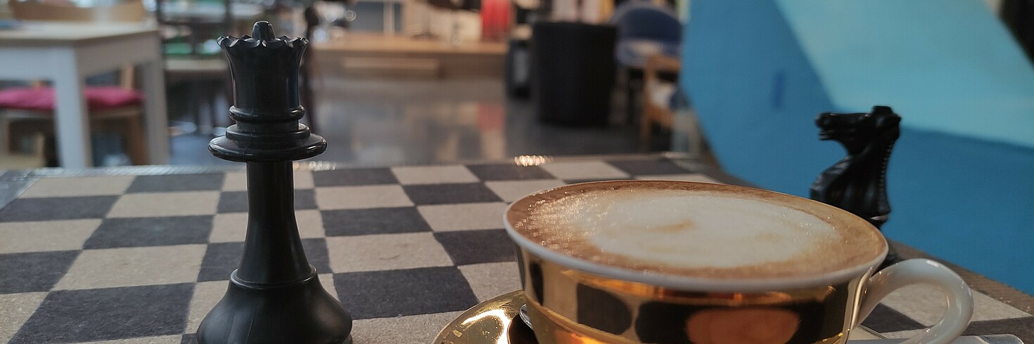Kaffeetasse und Schachfiguren