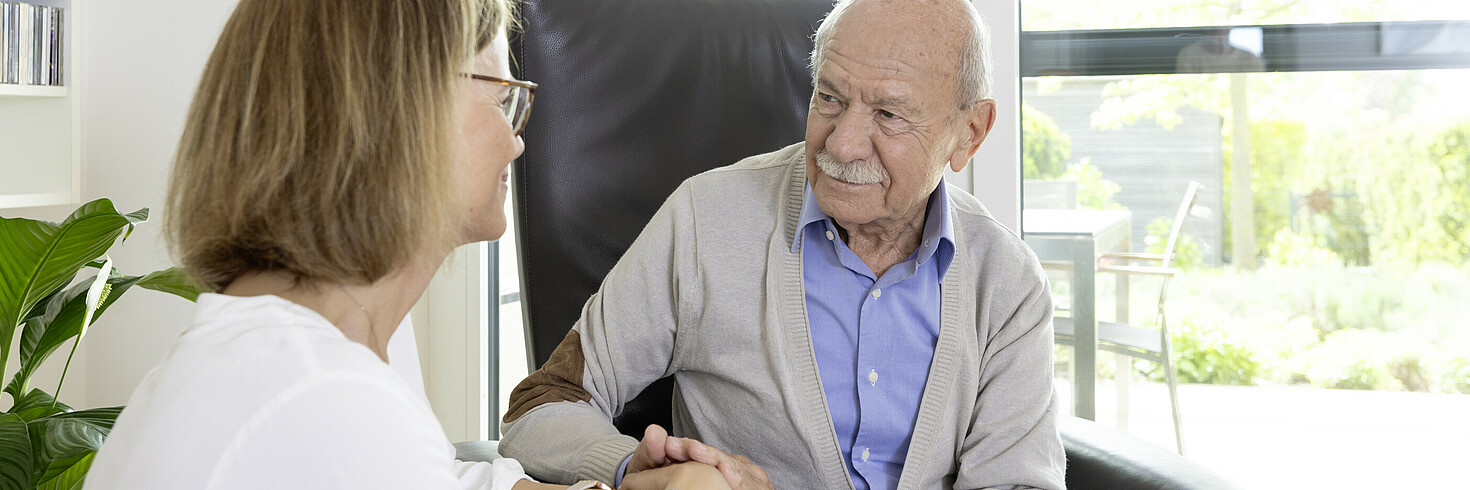 Ein älterer Herr blickt seine Tochter an.