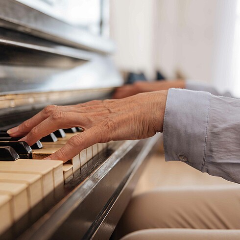 Hände eines Mannes beim Klavierspielen