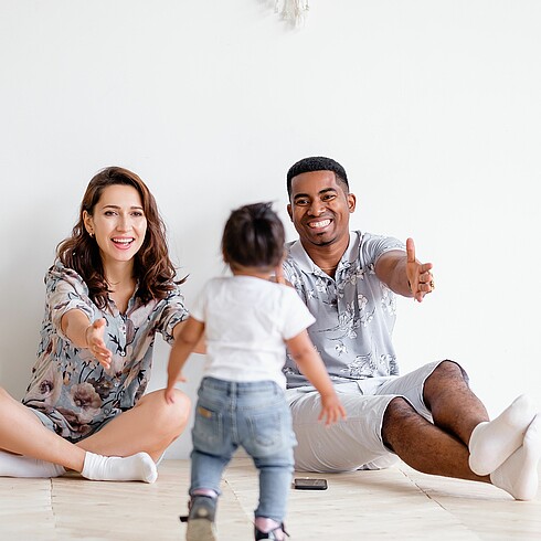 Familie mit Kleinkind, am Boden sitzend