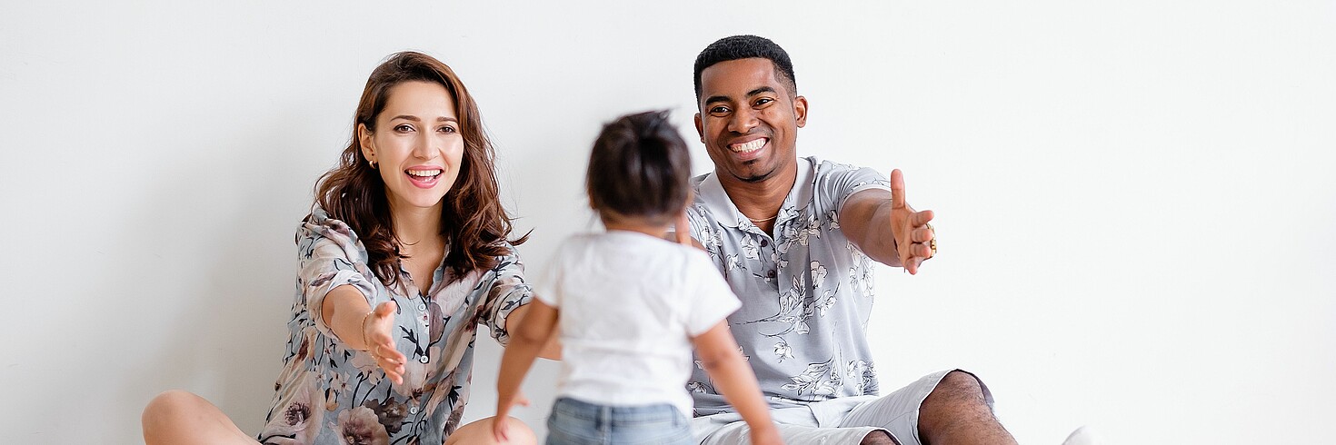 Familie mit Kleinkind, am Boden sitzend