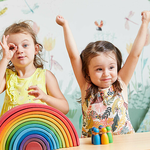 Drei Kinder im Vorschulalter formen mit den Händen ein Fernrohr und gucken durch