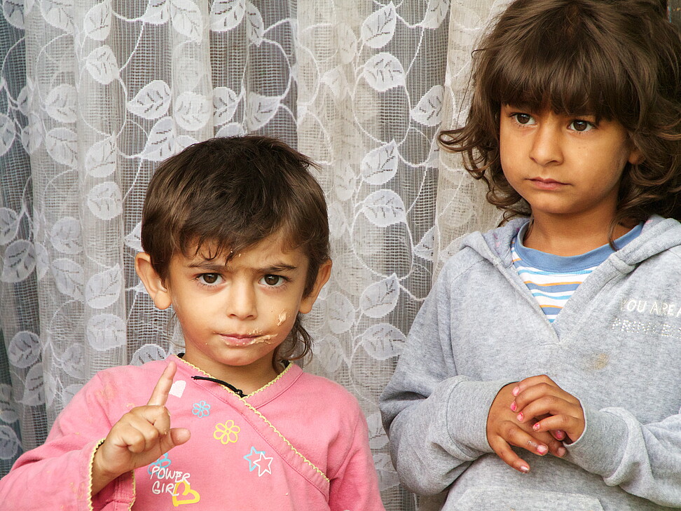 Zwei kleine Kinder vor Vorhang