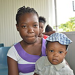 Mutter mit Kind am Schoß im Warteraum vom Krankenhaus in Haiti