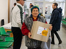 Frau mit Hilfspaket in der Ukraine