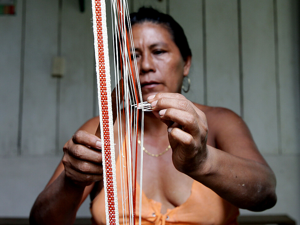 Frau beim Knüpfen von indigenen Bändern