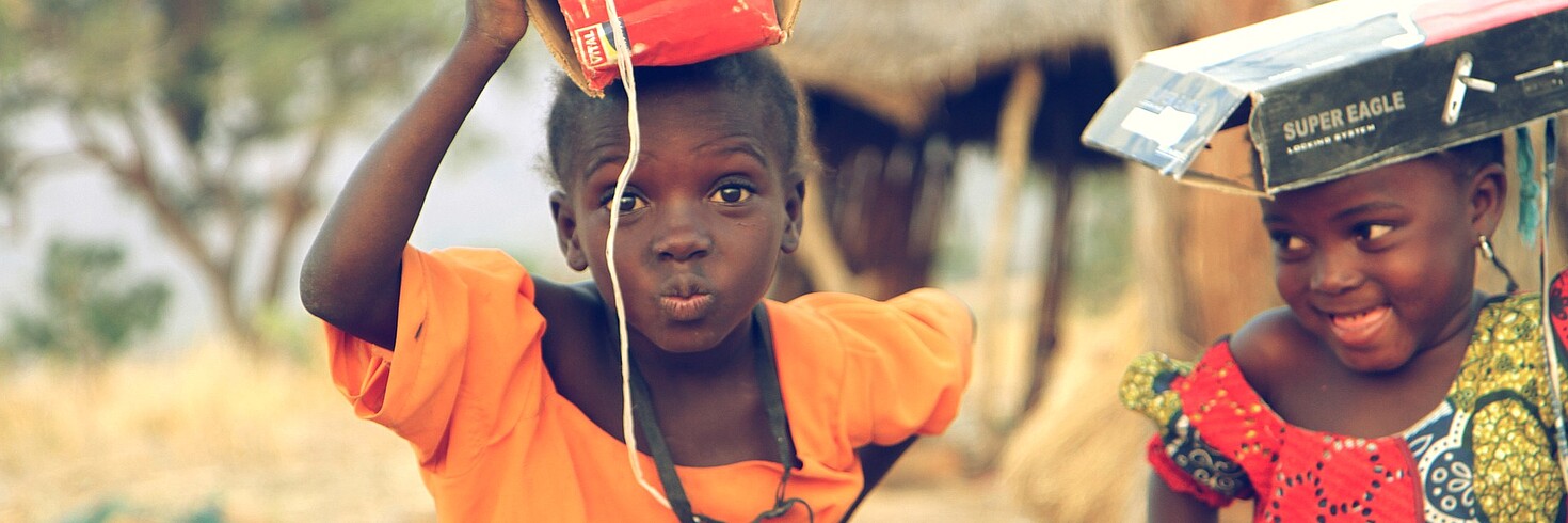 Zwei Mädchen mit Kartons am Kopf in Afrika