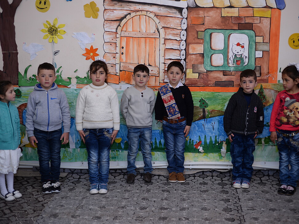 Kindergartenkinder vor bemalter Innenwand in Armenien