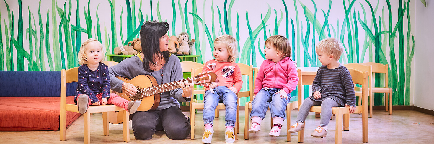 Kinder singen zu Lied auf Gitarre