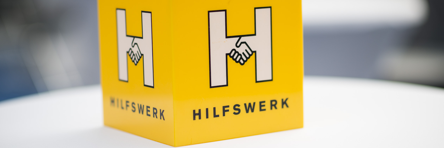 Hilfswerk Logo Würfel auf einem Tisch