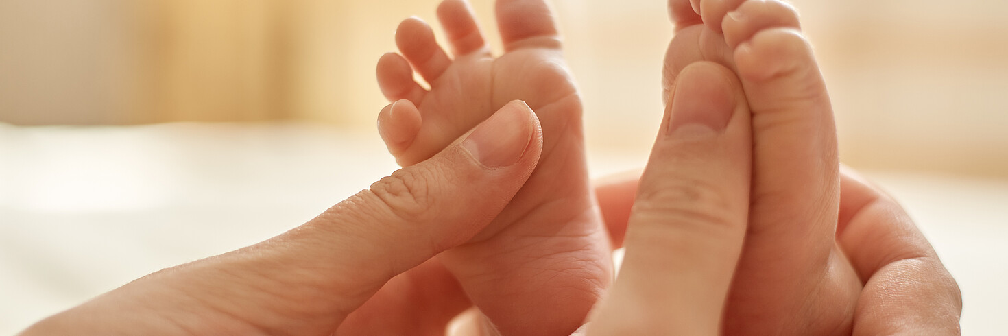 Mutter massiert Babyfüße