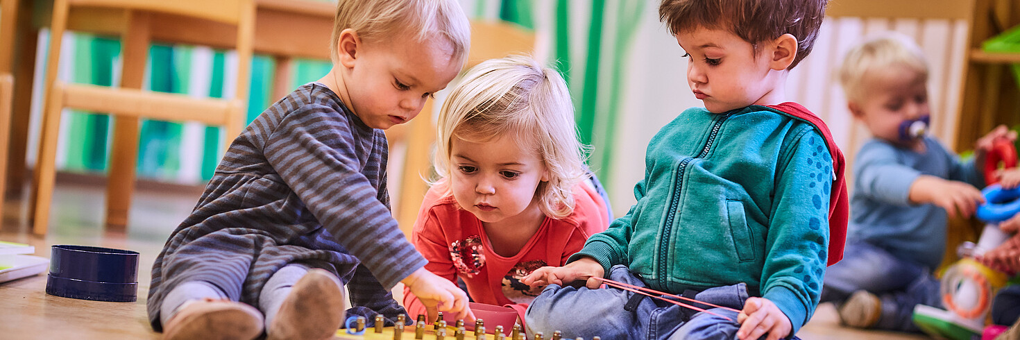 drei Kinder spielen gemeinsam