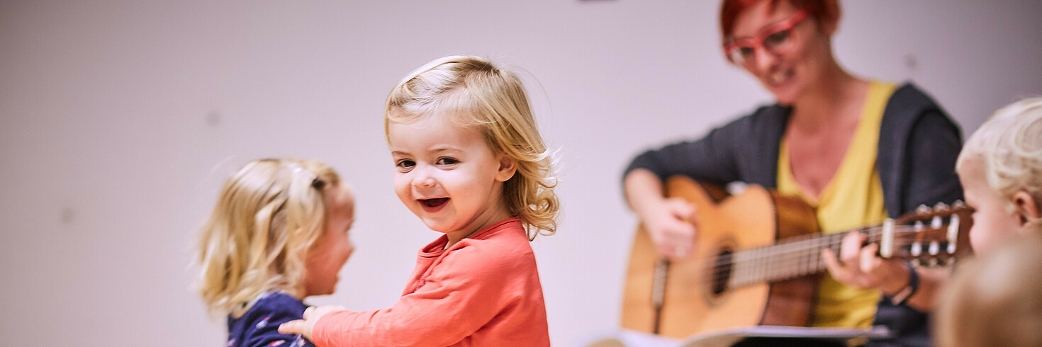 Kinder tanzen zu Lied auf Gitarre