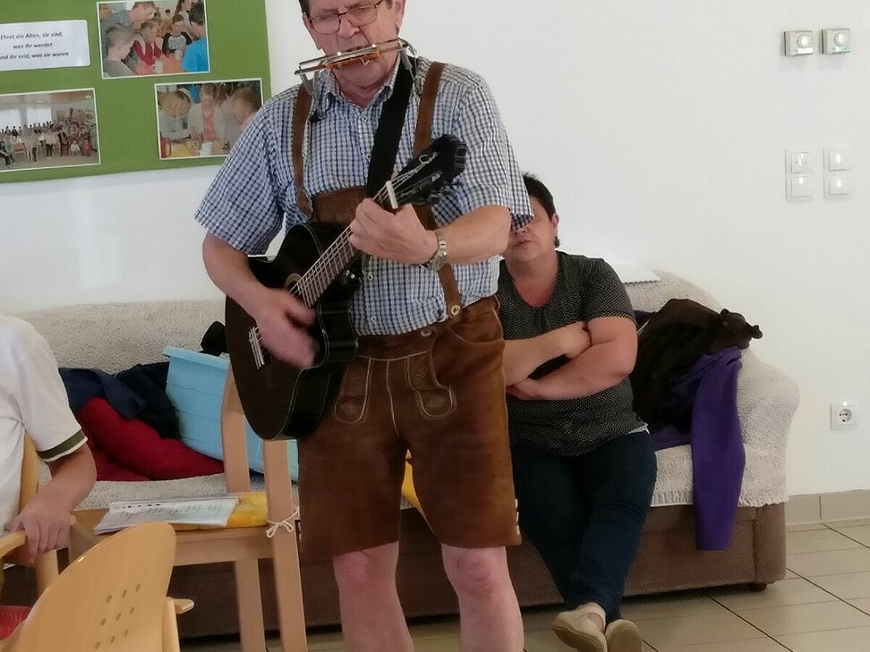 Musikant mit Gitarre und Mundharmonika