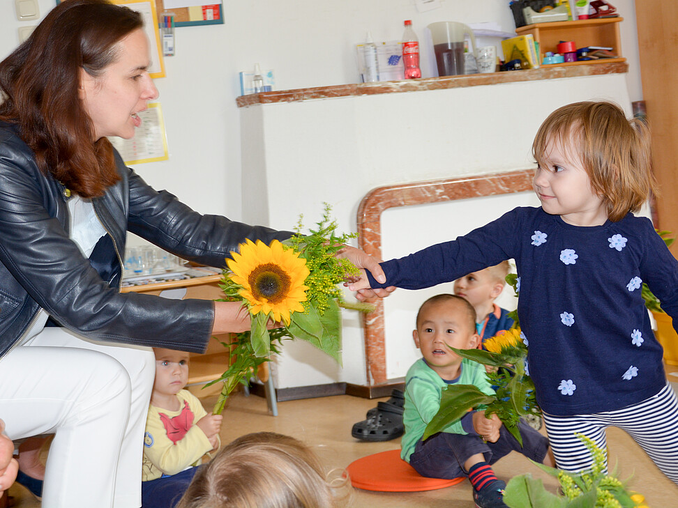 Kleines Mädchen überreicht Frau BM Karmasin eine Blume