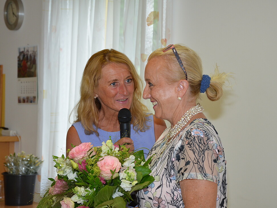 2 Damen bei der Überreichung von Blumen