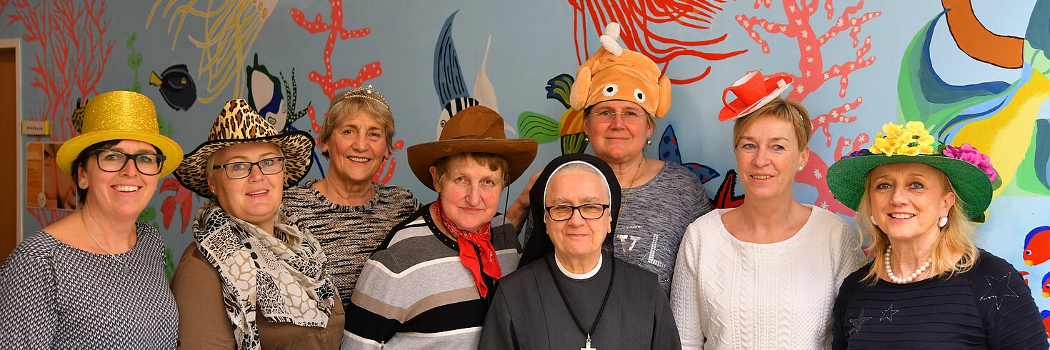 8 maskierte Damen stellen sich dem Gruppenfoto