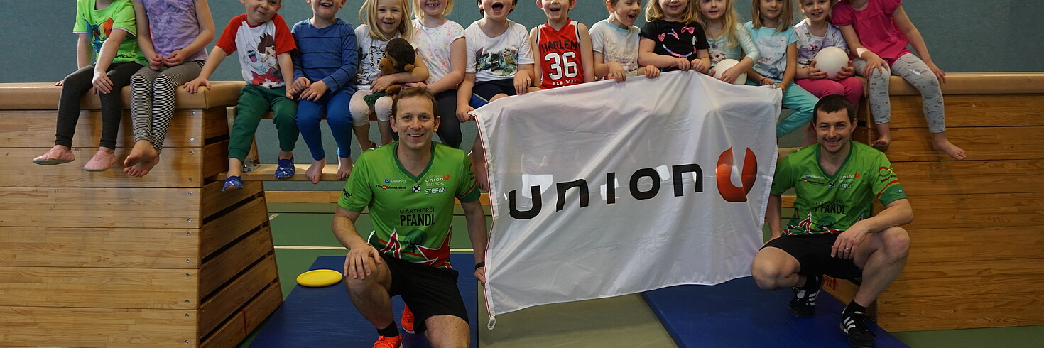 Gruppenfoto der Kindergartenkinder mit den Trainern und Transparent