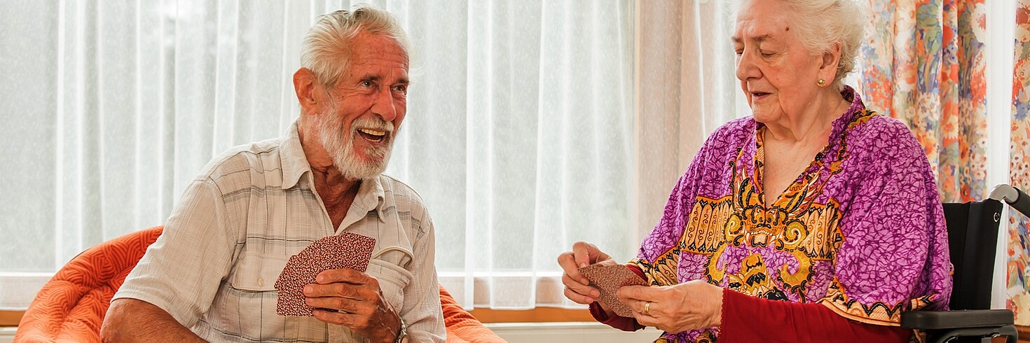 Zwei Senioren sitzen im Senioren Tageszentrum gemeinsam