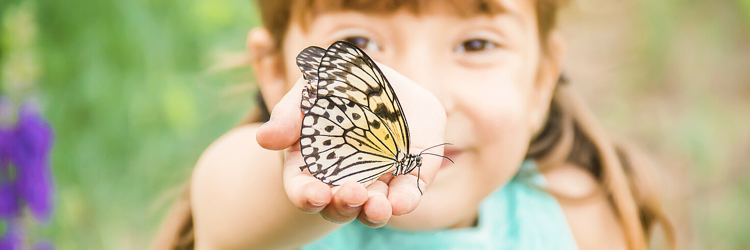 Kind mit Schmetterling in der Hand