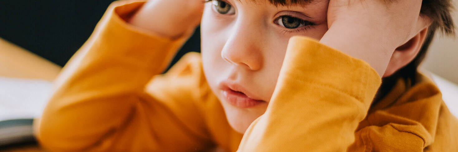 Kind sitzt vor Hausaufgaben