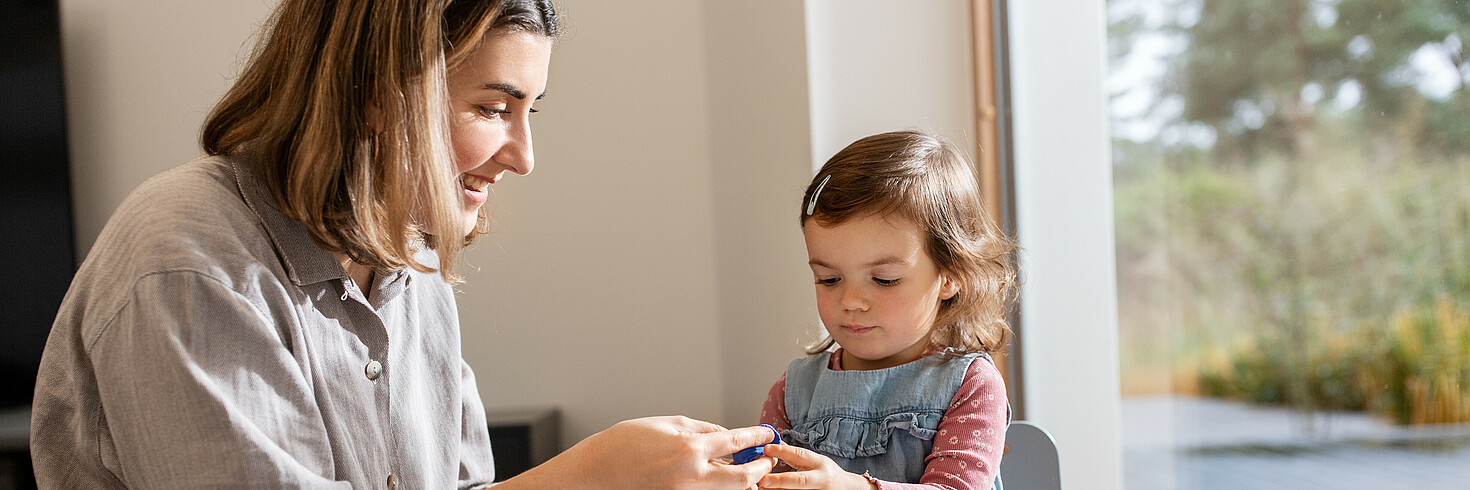 Tagesmutter bastelt mit Kind