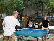 Zwei Personen spielen Tischtennis.