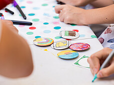 Bunte Buttons liegen auf einem Tisch.