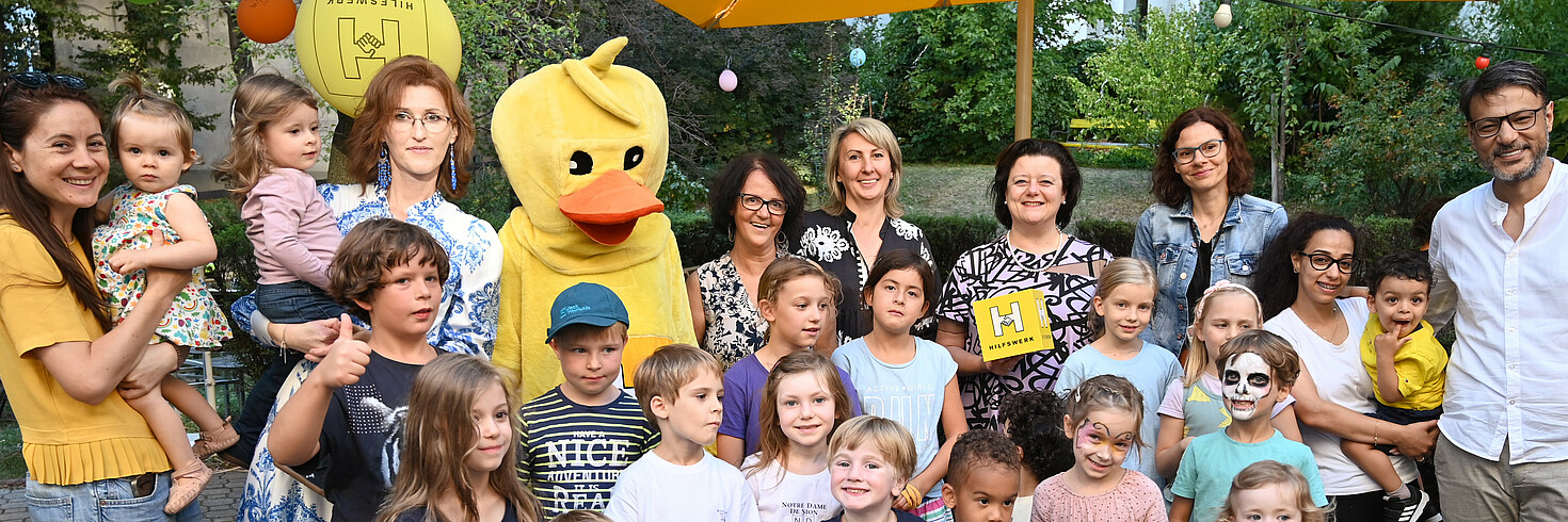 Gruppenfoto im Garten mit Erwachsenen und Kindern