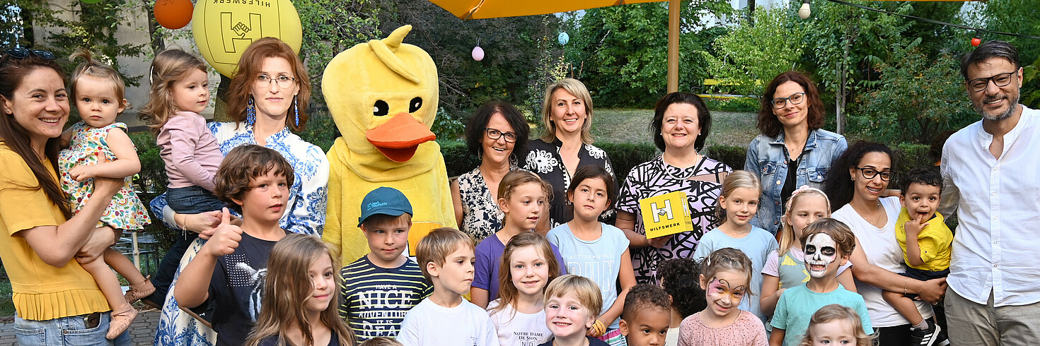 Gruppenfoto im Garten mit Erwachsenen und Kindern