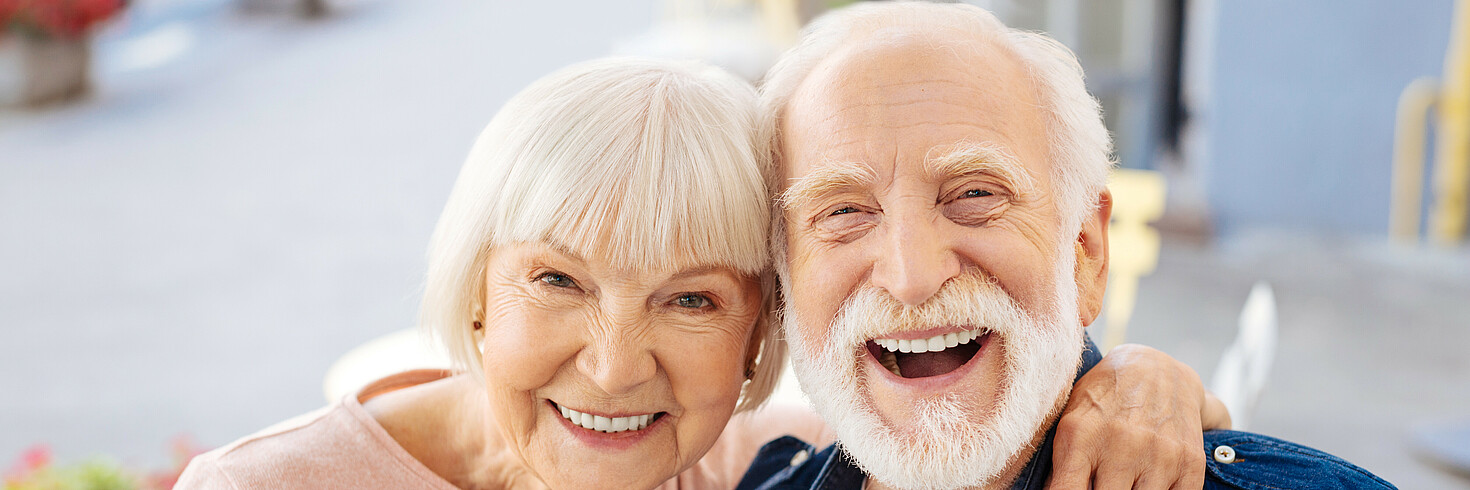 Ältere Frau und älterer Mann lachen in die Kamera