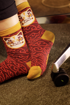 Ein paar Füße, das in Socken auf dem Boden steht.