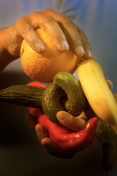 Zwei Hände halten verschiedenes Obst und Gemüse.