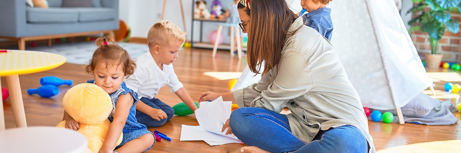 Tagesmutter spielt mit Kindern