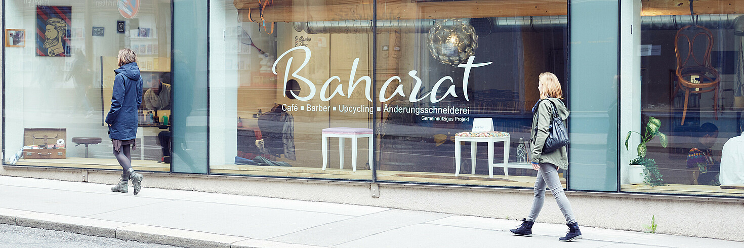 Fensterfassade von Baharat, Menschen gehen vorbei uns sehen hinein