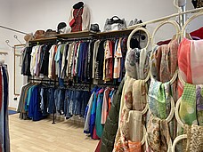 Kleidung aus zweiter Hand an Kleiderbügeln.