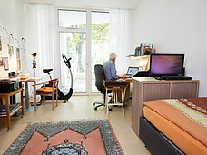 Ein Zimmer der Wohngemeinschaft mit Bett und Schreibtisch