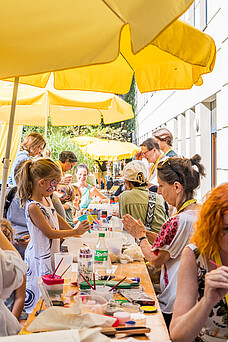 Ein Tisch an dem Kinder im Gesicht bemalt werden.