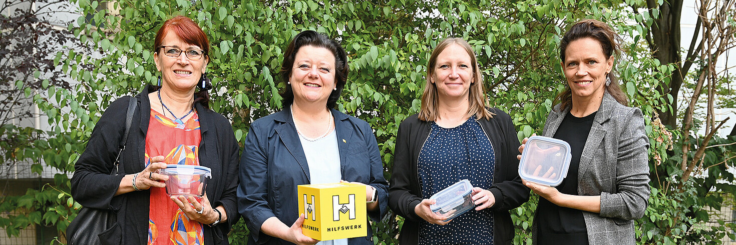 Gruppenfoto von vier Frauen. Drei davon haben ein Mehrweggeschirr in der Hand. 